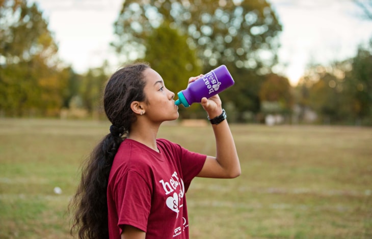 A Girls on the Run participant stretches at program practice to prepare for the day.